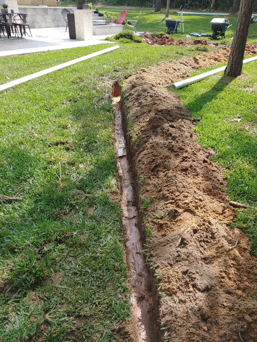 Narrow trench with a soil berm along the edge of a lawn